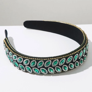 Détail des cristaux marquise émeraude et chaînes de perles dorées sur serre-tête vintage