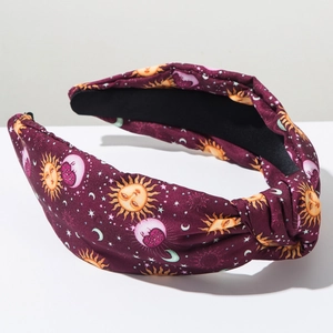 Detail of vintage knotted headband featuring celestial sun and moon patterns on purple fabric