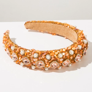 Detail eines Perlen-Stirnbands mit orangen Steinen, Perlen und rosa Kristallen