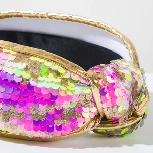 Detail of colorful sequins and golden knot texture on high-top headband