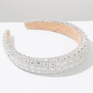 Close-up of sparkling rhinestones and soft brown velvet lining on luxury silver headband