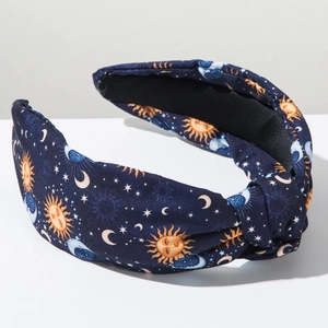 Detail of navy blue knotted headband with vintage sun moon and star celestial patterns