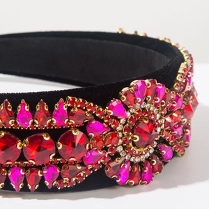 Macro detail of Baroque headband showing red rhinestones on black velvet base