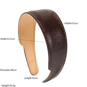 Détail d'un serre-tête en cuir marron foncé avec texture grainée et coutures oranges
