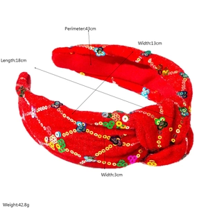 Vue détaillée du bandeau noué à paillettes rouges avec broderie florale colorée