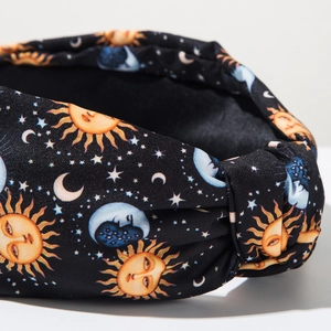Detail of celestial fabric headband featuring vintage sun, moon, and star patterns