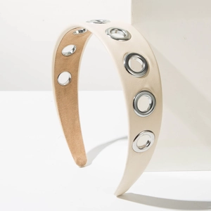 Détail du serre-tête en cuir crème avec œillets métalliques argentés et doublure intérieure