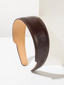 Détail du serre-tête en cuir marron foncé avec couture jaune et grain de litchi