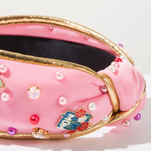 Detail of pink knotted headband with MOM heart charm, pearls, and rhinestones