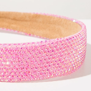 Gros plan de strass roses sur serre-tête large avec doublure en velours beige