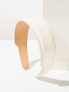 Détail d'un serre-tête en cuir blanc avec des coutures contrastées orange élégantes