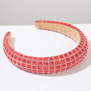 Close-up of red thick headband with sparkling rhinestones and beige velvet lining