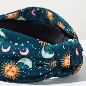 Detailed macro view of retro wide knotted headband with celestial sun and moon prints