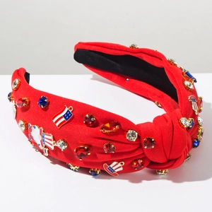 Détail d'un serre-tête noué rouge avec strass étoilés et breloques de chapeau USA