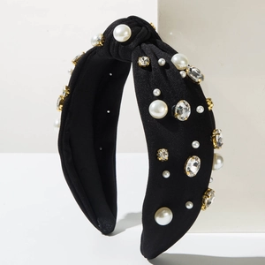 Détail d'un serre-tête noué en tricot avec des perles blanches et des strass en verre