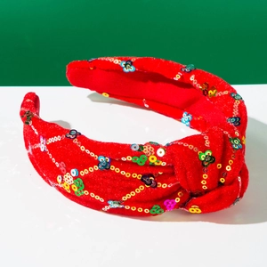 Détail du serre-tête en velours rouge avec sequins colorés pour fête de Noël