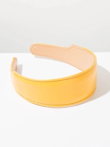 Vue détaillée du serre-tête en cuir jaune montrant la texture grainée et les coutures