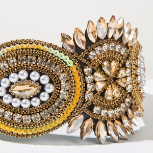 Detail of luxury baroque headband with champagne crystals, white pearls and gold sequins