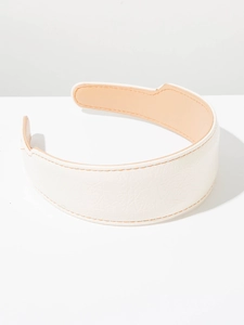 Détail du serre-tête en similicuir blanc avec coutures brunes et doublure