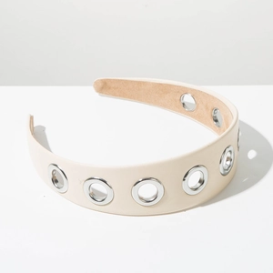 Détail d'un serre-tête large crème minimaliste avec œillets métalliques et similicuir