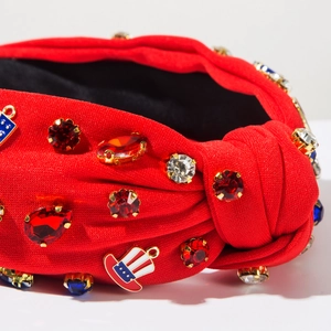Gros plan du bandeau noué rouge avec breloques drapeau américain et strass brillants