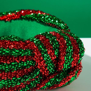 Détail macro du serre-tête noué à paillettes métalliques rouge et vert pour Noël