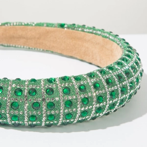 Detailed close-up of luxurious green rhinestone padded headband with crystal beads