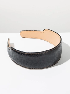 Détail du serre-tête large en cuir noir avec surpiqûres orange et doublure intérieure lisse