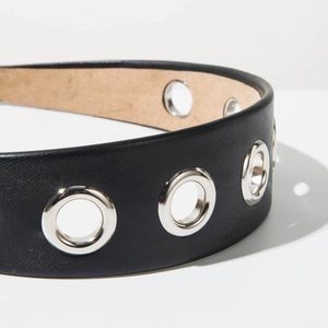 Gros plan d'un serre-tête en cuir noir avec œillets métalliques et doublure beige