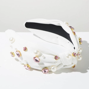 Vue détaillée d'un serre-tête noué blanc orné de strass roses et de perles blanches