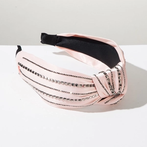 Detail of pink satin knotted headband featuring grey square studs and bead chain rows