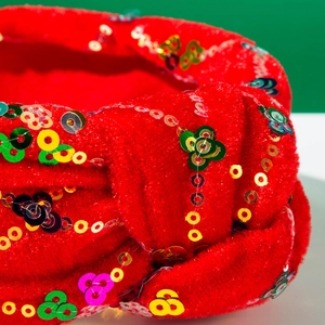Macro d'un serre-tête en velours rouge avec sequins colorés aux motifs floraux festifs