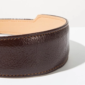 Détail du serre-tête en cuir marron foncé avec des coutures orange contrastées et brillantes