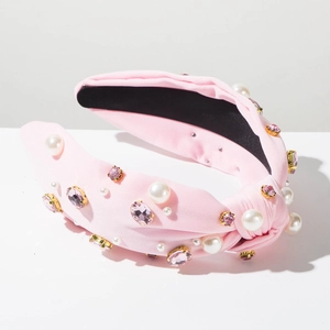 Détail du serre-tête noué rose orné de perles blanches et de cristaux scintillants