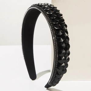 Detail of baroque black crystal headband with silver beaded chain edge on white stand
