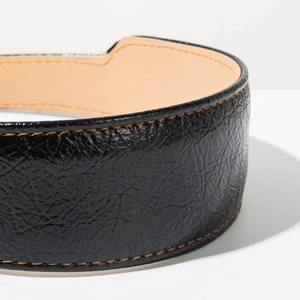 Détail d'un serre-tête en cuir noir avec coutures orange contrastées et doublure intérieure