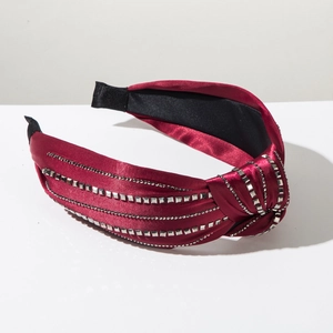 Detail of burgundy satin headband with silver square studs and wave pattern texture