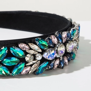 Detailed close-up of handmade velvet headband with colorful emerald and sapphire rhinestones