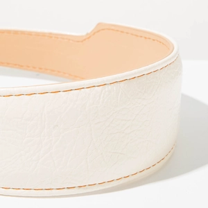 Gros plan sur serre-tête en cuir blanc avec couture orange et texture de qualité