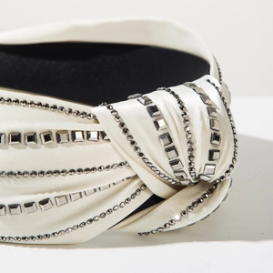 Detailed close-up of a cream knotted headband with silver rhinestones and satin finish
