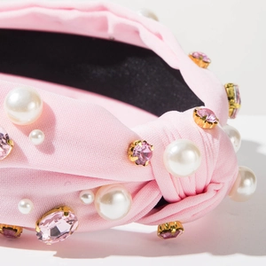 Détails du serre-tête noué rose avec des perles blanches et des pierres précieuses roses