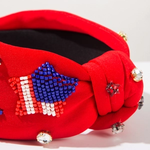 Dettaglio fascia rossa annodata con perline a bandiera americana e strass lucidi