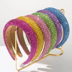 Gros plan de serre-têtes rembourrés avec strass colorés sur un support doré élégant
