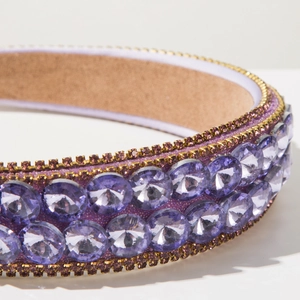 Detail of baroque headband with purple crystals and gold settings on non-slip velvet liner