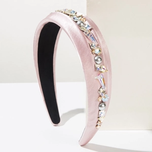 Détail d'un serre-tête en satin rose orné de strass et de perles grises fantaisie