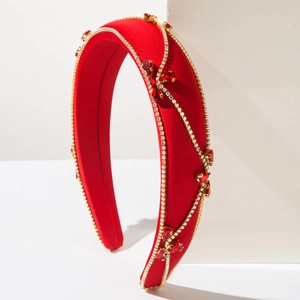 Detail view of red velvet Baroque headband with gold chains and ruby gemstones