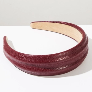 Detail of burgundy thick sponge headband featuring snakeskin texture and beige suede lining