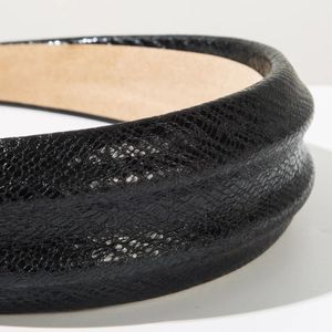 Macro shot of black snake pattern faux leather headband with soft beige velvet lining