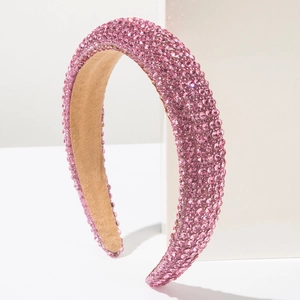 Détail du serre-tête rose avec strass brillants montrant les cristaux et la doublure en velours