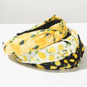 Dettaglio di tre cerchietti annodati in tessuto con stampe limone su giallo bianco e nero